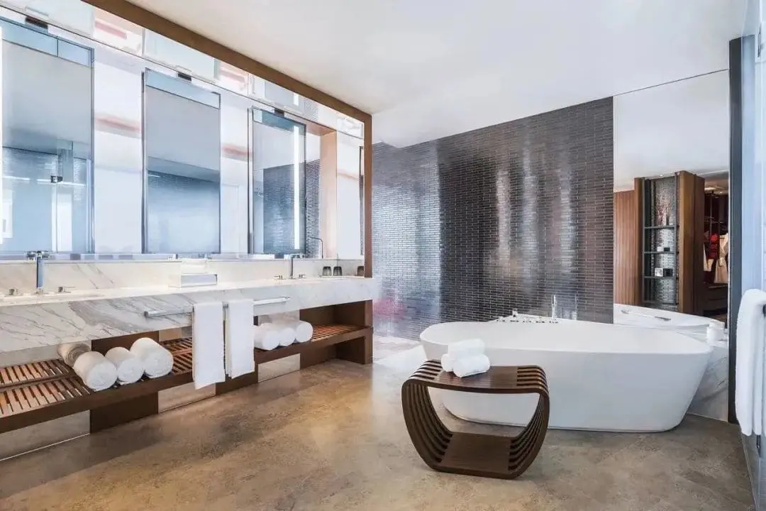 Large format metallic tiles in a luxury modern bathroom with a freestanding tub.