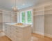 White modern walk-in closet with central drawer island and open hanging racks